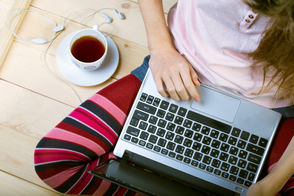 Teen girl sitting with a laptop